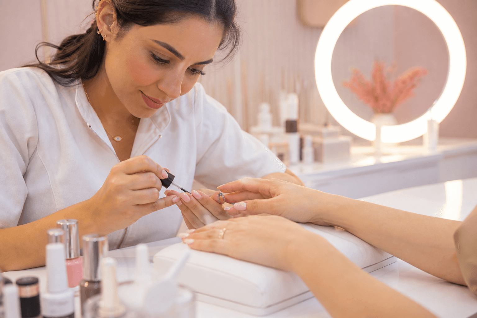 Manicure finalizando o atendimento de uma cliente